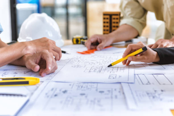 Deux professionnels analysant des plans sur un chantier